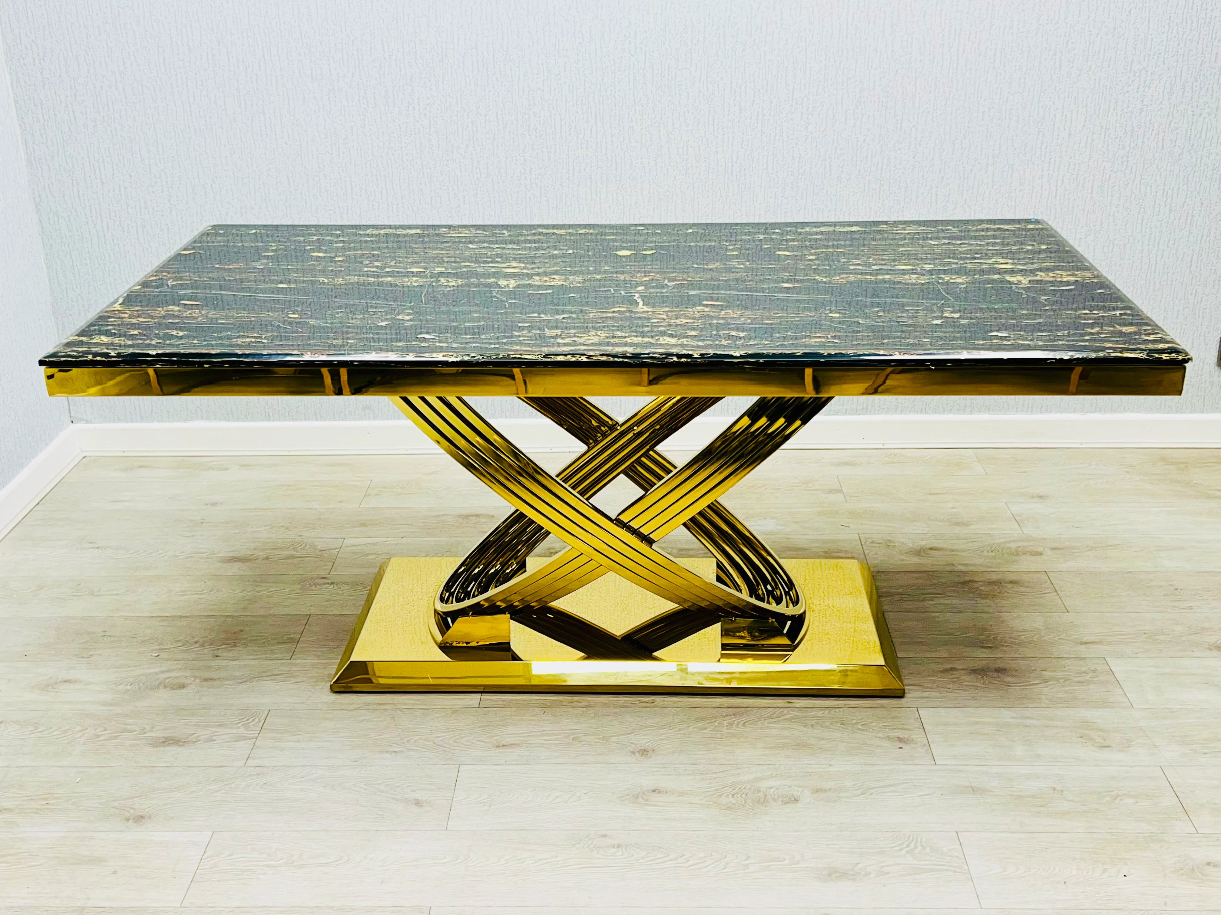 Black and gold marble dining table with a polished gold geometric pedestal base and luxurious modern design