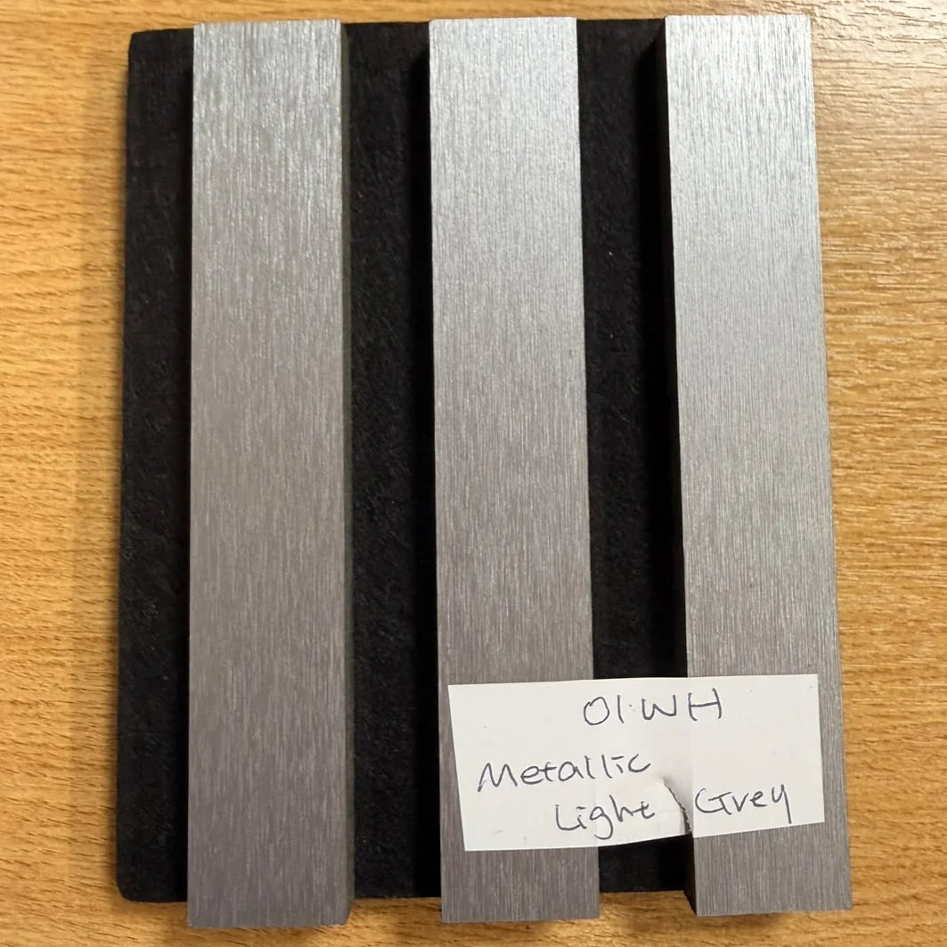 Close-up of metallic light grey slatted wall panel finish