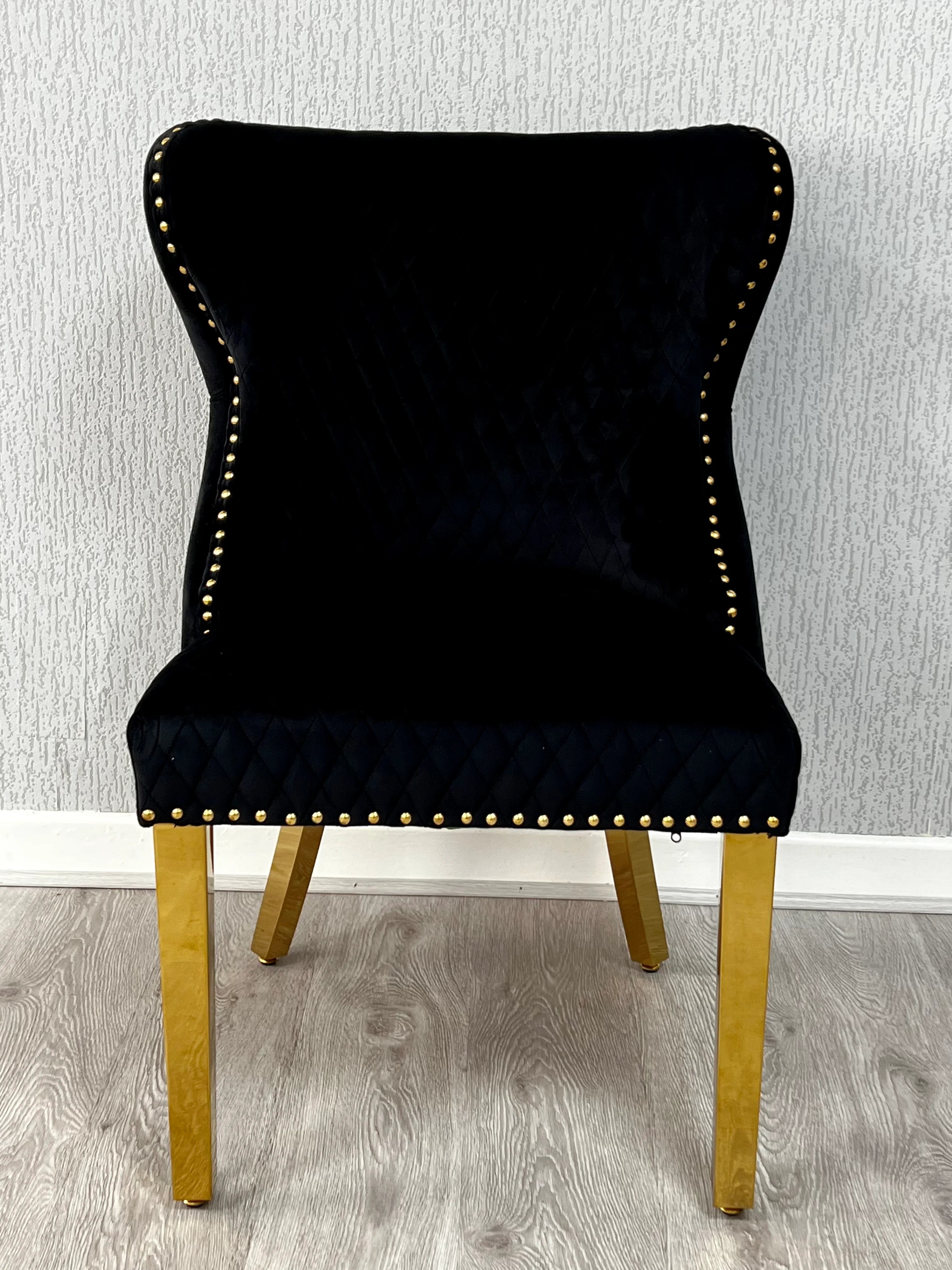 Premium gold dining chairs paired with a high-gloss marble table for a refined contemporary dining space