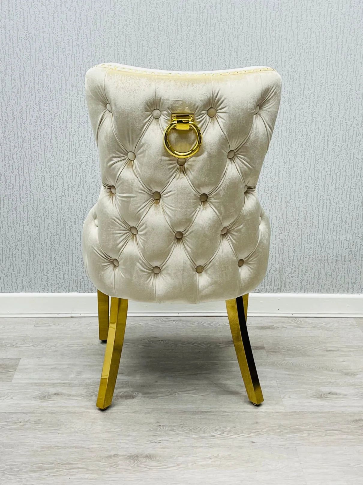 Luxury dining set combining a cream marble tabletop, polished gold pedestal and elegant upholstered lion knocker seating