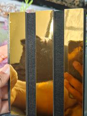 Side profile of shiny gold slatted acoustic wall panel